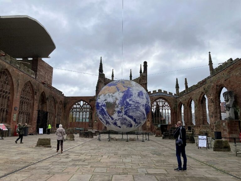 A sculpture of the world displayed in the old Coventry Cathedral ruins
